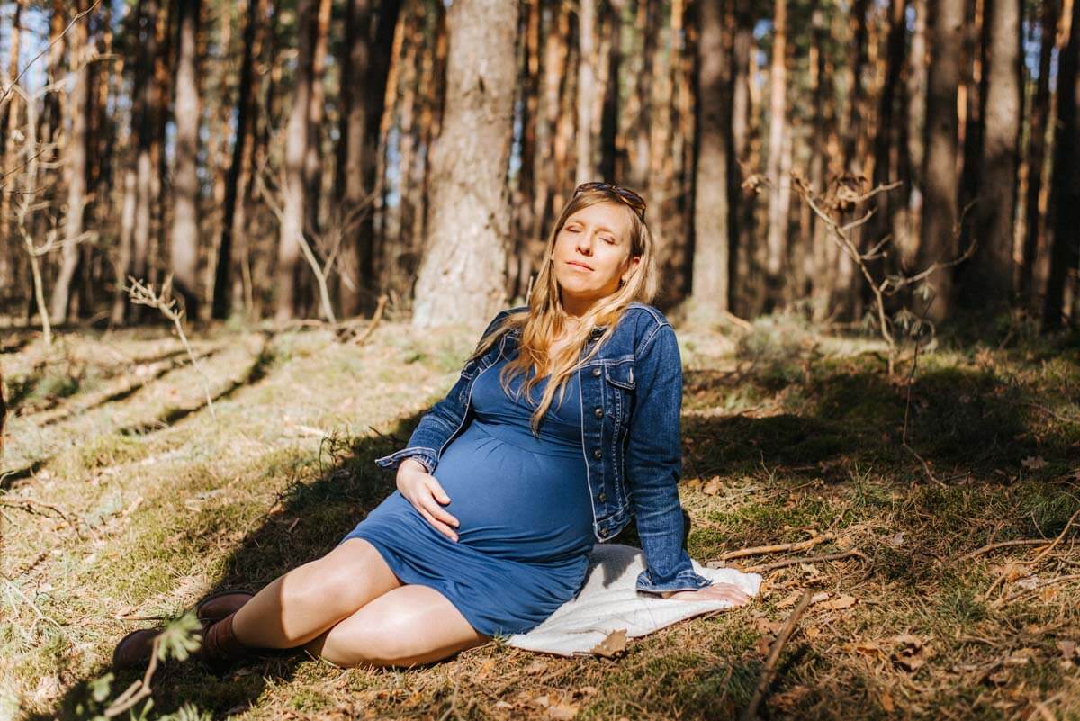 kobieta w ciąży w czasie sesji zdjęciowej w lesie